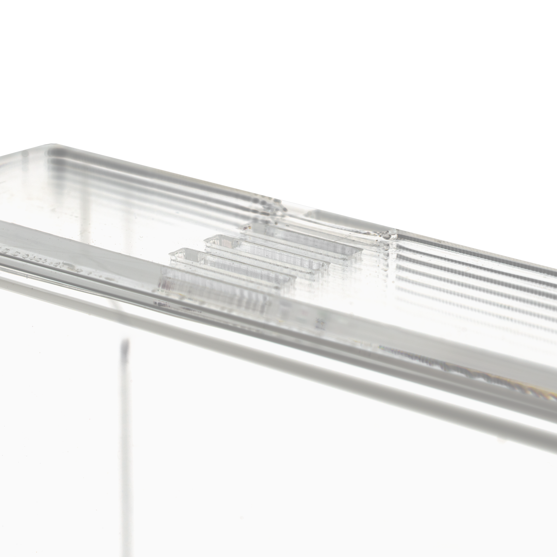 Nahaufnahme des transparenten, milchigen Einmalhandschuhs Spender (250 x 135 x 55-90 mm) der AMPri Handelsgesellschaft mbH, eines rechteckigen Acryl-Dispenserhalters mit geriffelten Kanten auf einfarbig weißem Grund.