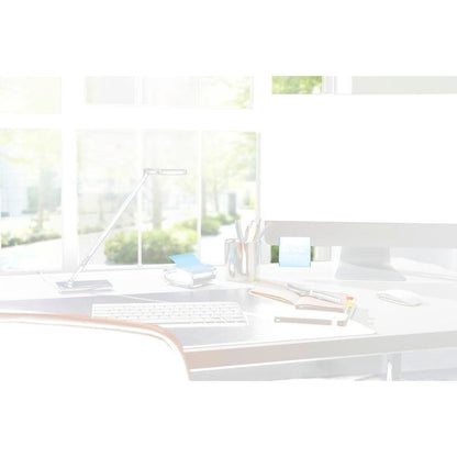 Μια σύγχρονη διάταξη γραφείου με έναν διανομέα 3M Post-it® Z-Notes PRO σε μαύρο χρώμα με κίτρινες Post-it® Super Sticky Z-Notes (76x76 mm, 90 φύλλα/μπλοκ), σημειωματάρια, στυλό και μια λάμπα μπροστά από μεγάλα παράθυρα με ηλιακό φως και πράσινα δέντρα έξω.