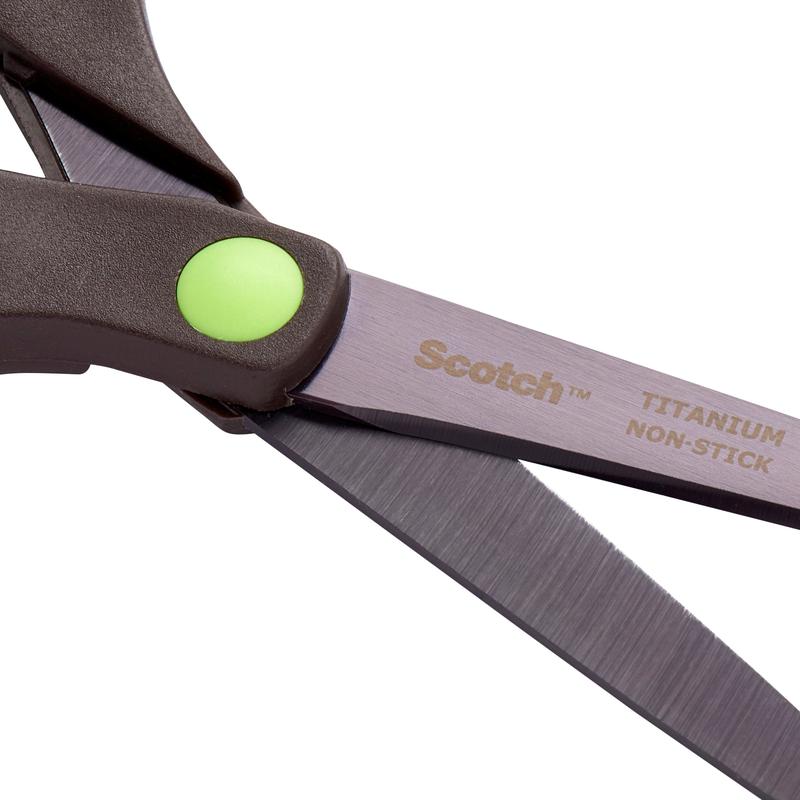 Κοντινή λήψη ενός ψαλιδιού Scotch™ Titan της 3M Deutschland GmbH, 20 cm, με αντικολλητικές λεπίδες από τιτάνιο και μια πράσινη, κυκλική λεπτομέρεια κοντά στη σύνδεση της λαβής.