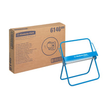 Ένα κουτί με την επιγραφή "Kimberly-Clark Professional™ Επιτοίχια βάση για ρολά χαρτιού - Μεγάλο ρολό" της Kimberly-Clark GmbH βρίσκεται δίπλα στο μπλε πλαίσιο διανομής του, και τα δύο μπροστά από ένα λευκό φόντο.