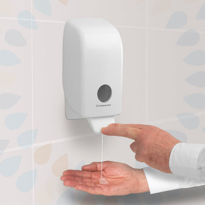 Ένα άτομο πατάει έναν διαφανή διανομέα Kleenex® Extra Gel Απολυμαντικό Χεριών της Kimberly-Clark GmbH, που είναι τοποθετημένος σε τοίχο με πλακάκια, και απελευθερώνει το απολυμαντικό χεριών από μια κασέτα 1 λίτρου στην ανοιχτή παλάμη του.
