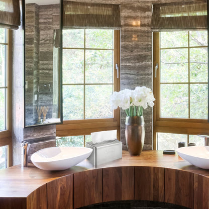 Ένα μοντέρνο μπάνιο με ξύλινο πάγκο, δύο λευκούς νιπτήρες, καφέ περσίδες, ένα βάζο με λευκά λουλούδια και μια κομψή θήκη χαρτοπετσετών Kleenex® από ανοξείδωτο ατσάλι της Kimberly-Clark GmbH με λειτουργία εξαγωγής δίπλα στο κουτί χαρτομάντιλων. Έξω φαίνονται δέντρα.