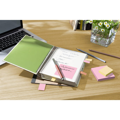 Ein Notizbuch mit handschriftlichen Notizen und 3M Post-it® Recycling Notes (38 mm x 51 mm, 100% PEFC) liegt aufgeschlagen auf einem Holztisch neben einem Laptop, Stiften und einer Vase mit weißen Gänseblümchen.