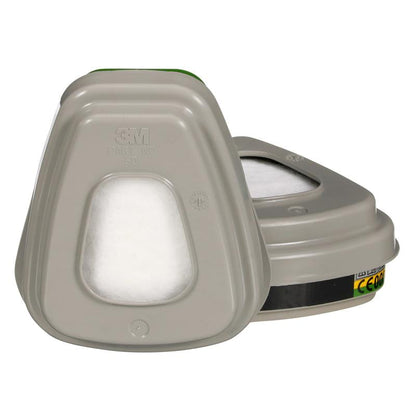 Απεικονίζονται δύο γκρι 3M™ σετ φίλτρων 6004-1SP ABEK1P3 συνδυαστικές κασέτες φίλτρων με λευκά φίλτρα (2x6059, 2x5935, 2x501) από την 3M Deutschland GmbH; μία είναι όρθια με επωνυμία και στοιχεία, η άλλη βρίσκεται επίπεδα πίσω της.