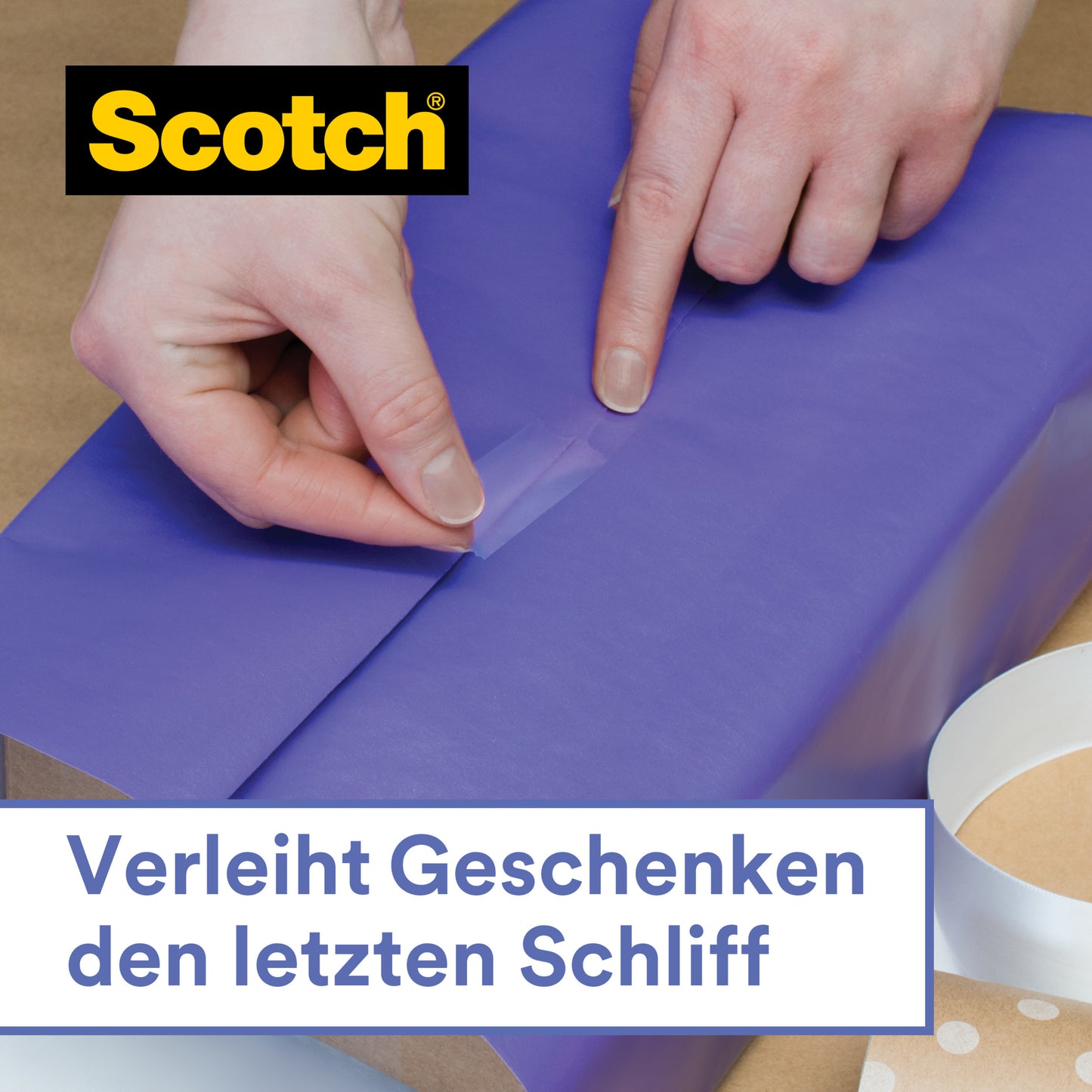 Eine Person verschließt blaues Geschenkpapier mit dem Scotch® Geschenk-Klebeband im Handabroller, CAT 15 (19 mm x 15 m) von 3M Deutschland GmbH. Zusätzliches Klebeband und der Abroller liegen daneben. Deutscher Text: "Verleiht Geschenken den letzten Schliff.