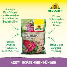 Ein Beutel Neudorff Shop Azet HortensienDünger steht aufrecht auf einem weißen Hintergrund mit grünen und gelben Akzenten und zeigt einen deutschen Text über seine Vorteile für Hortensien, Kamelien und Bougainvilleas in Ihrem Garten für eine wunderschöne Blüte.