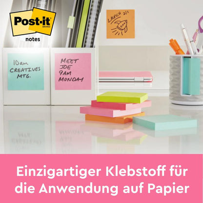 Ένα γραφείο με πολύχρωμα Post-it® Notes της 3M Deutschland GmbH (76 x 127 mm, 100 φύλλα/μπλοκ, 6 μπλοκ/πακέτο, 100% PEFC), στυλό και μια θήκη στυλό. Τα σημειώματα είναι εφοδιασμένα με βοηθήματα μνήμης. Κείμενο κάτω: "Μοναδική κόλλα για χαρτί".