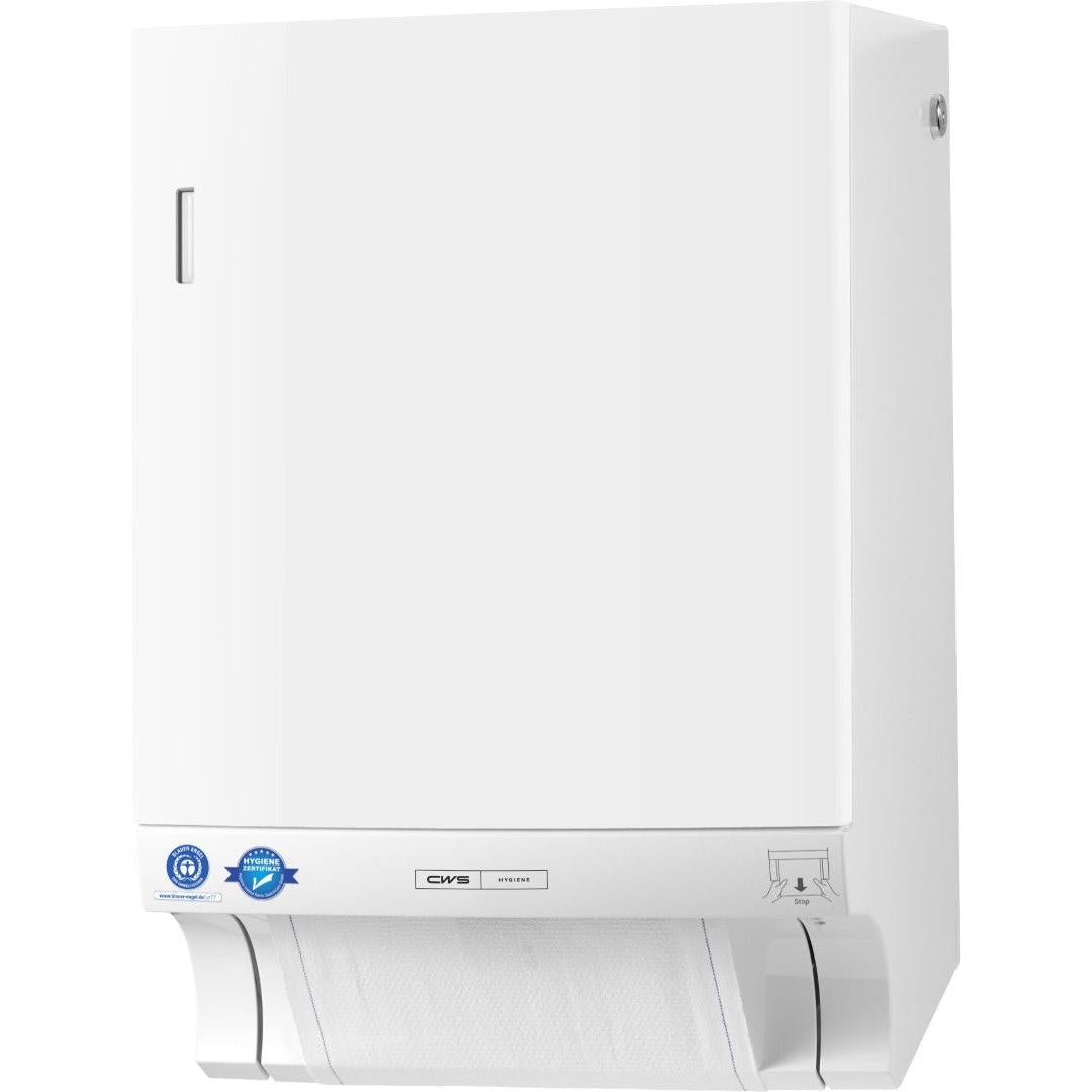 Ένας λευκός διανομέας υφασμάτινης πετσέτας CWS ParadiseLine Dry Slim με συμπεριλαμβανόμενο πάνελ και λεπτό σχεδιασμό είναι στερεωμένος στον τοίχο και δείχνει ένα μερικώς αφαιρεμένο φύλλο στο κάτω μέρος. Μπλε αυτοκόλλητα, μια μικρή ασημένια ετικέτα και μια εικονογραφημένη οδηγία βρίσκονται κοντά στο κάτω μέρος.