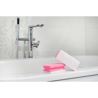 Ένα Scotch-Brite® Bath Griffschwamm XXL για το μπάνιο από την 3M Deutschland GmbH βρίσκεται στην άκρη μιας λευκής μπανιέρας, έτοιμο για καθαρισμό, με χρωμέ βρύση και τοιχοποιία με πλακάκια στο φόντο. 1 τεμάχιο ανά συσκευασία.