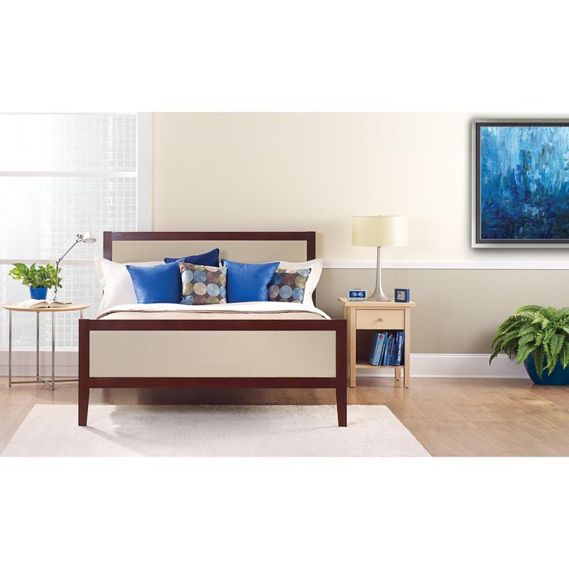 Ένα τακτοποιημένο κρεβάτι με λευκά και μπλε μαξιλάρια βρίσκεται μπροστά από έναν φωτεινό τοίχο, ο οποίος είναι κολλημένος με την ταινία κάλυψης ζωγράφου ScotchBlue™ "Multi-Surface" της 3M Deutschland GmbH. Σε ένα κομοδίνο βρίσκονται μια λάμπα, ένα ρολόι, βιβλία και ένα φυτό σε γλάστρα δίπλα στο φωτεινό παράθυρο.