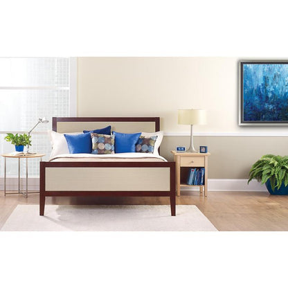 Ένα τακτοποιημένο κρεβάτι με λευκά και μπλε μαξιλάρια βρίσκεται μπροστά από έναν φωτεινό τοίχο, ο οποίος είναι κολλημένος με την ταινία κάλυψης ζωγράφου ScotchBlue™ "Multi-Surface" της 3M Deutschland GmbH. Σε ένα κομοδίνο βρίσκονται μια λάμπα, ένα ρολόι, βιβλία και ένα φυτό σε γλάστρα δίπλα στο φωτεινό παράθυρο.