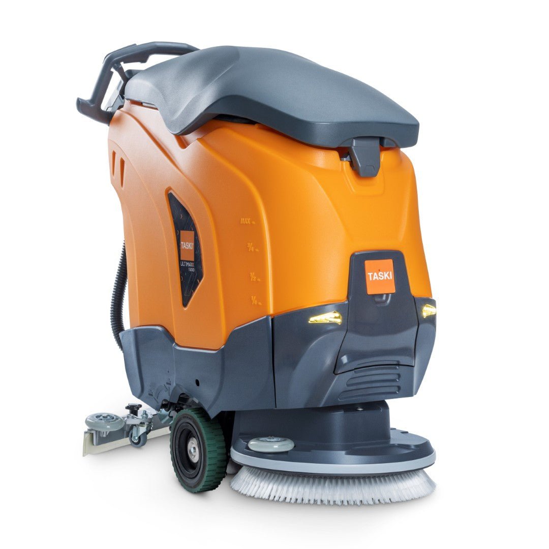 Μια πορτοκαλί-γκρι TASKI ULTIMAXX 1900 SD43 Performance BMS 13A EBU μηχανή καθαρισμού από Diversey, με δεξαμενή 42L, κίνηση τροχών, μονή δισκόπλακα 43cm, τροχούς, λαβή, πίνακα ελέγχου και ετικέτα "TASKI" στο μπροστινό μέρος.