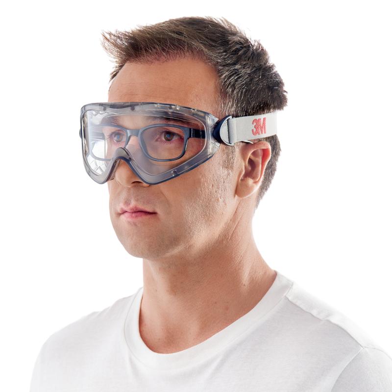 Ένας άντρας με κοντά καστανά μαλλιά και ένα απλό λευκό T-Shirt φορά μπροστά από ένα λευκό φόντο τα γυαλιά προστασίας 3M™ 2890, σφραγισμένα, διαφανής φακός της 3M Deutschland GmbH με μια λευκή ελαστική ταινία με την επιγραφή "3M".