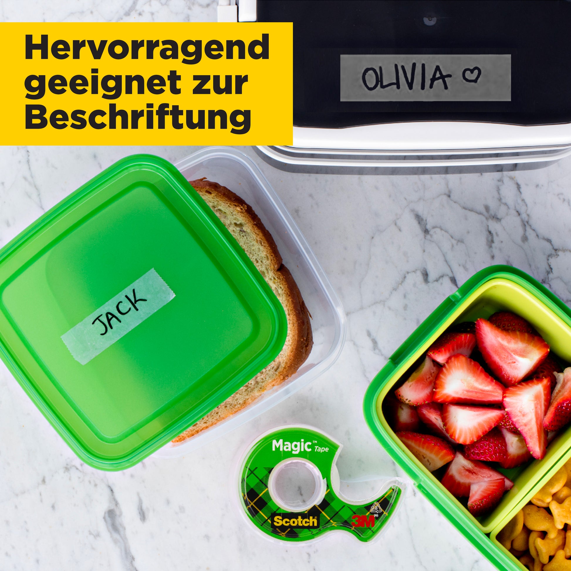 Ein Sandwich in einem Behälter mit der Aufschrift "JACK", eine Obst- und Nussbox, eine Brotdose mit der Aufschrift "OLIVIA" sowie 3M Deutschland GmbH Scotch® Magic™ Unsichtbares Klebeband (19 mm x 25 m) mit Handabroller und deutscher Beschriftungsinfo zur Eignung.