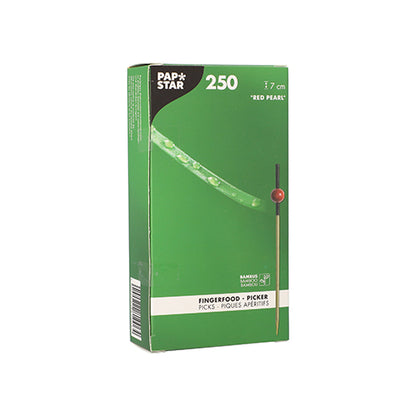 Σε ένα πράσινο κουτί με την επιγραφή «PAPSTAR 250 Fingerfood-Picker» της PAPSTAR GmbH βρίσκονται οικολογικά, βιοδιασπώμενα μπαμπού σουβλάκια με μια κόκκινη χάντρα που φέρει μοτίβο μπαμπού και υποδεικνύει το υλικό μπαμπού.