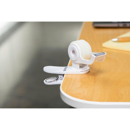 Ο διανομέας ταινίας Scotch™ Clip & Twist C19 με αόρατη ταινία Scotch® Magic™ (19 mm × 8,89 m) της 3M Deutschland GmbH είναι κλιπάρει δίπλα σε ένα σημειωματάριο και ένα στυλό σε ένα ξύλινο τραπέζι.