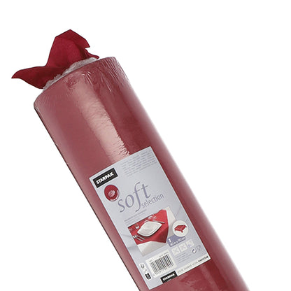 Ένα μερικώς ξεπακεταρισμένο ρολό κόκκινου τραπεζομάντιλου Starpak, όμοιο με ύφασμα "Soft Selection", με μια ετικέτα με οδηγίες χρήσης και εικόνες μιας διακόσμησης τραπεζιού.