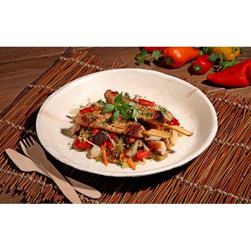 Σουβλάκια κοτόπουλου στη σχάρα με πολύχρωμο τηγανητό λαχανικών σερβίρονται σε ένα PAPSTAR 6 πιάτο, από φύλλο φοίνικα "pure" στρογγυλό της PAPSTAR GmbH - φιλικό προς το περιβάλλον σερβίτσιο, κομψά παρουσιασμένο σε υφασμάτινη βάση με ξύλινα μαχαιροπίρουνα και φρέσκες πιπεριές στο πλάνο.