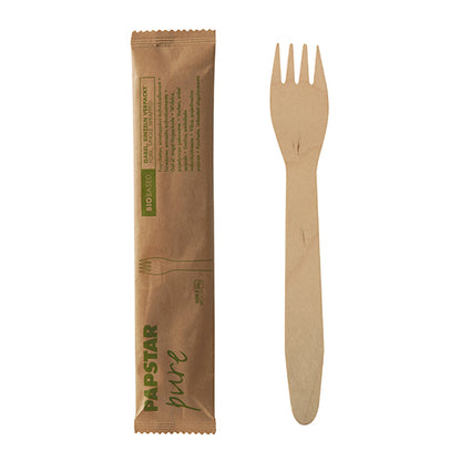 Μια ξύλινη PAPSTAR πιρούνα "pure", 15,5 cm, συσκευασμένη μεμονωμένα σε συρρικνωμένο φιλμ (50 τεμάχια), βρίσκεται δίπλα στην κλειστή καφέ συσκευασία της από την PAPSTAR GmbH με πράσινη εκτύπωση και απλό σχέδιο.