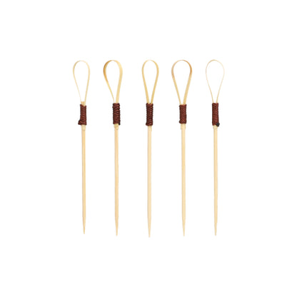 Σαράντα PAPSTAR Fingerfood Picker 10 cm "Loop" Cocktail Picks της PAPSTAR GmbH, ιδανικά για σνακ και fingerfood, χαρακτηρίζονται από μοναδικό σχεδιασμό Loop με τμήματα τυλιγμένα σε σκούρο καφέ, τα οποία είναι τοποθετημένα όρθια μπροστά από ένα απλό λευκό φόντο.