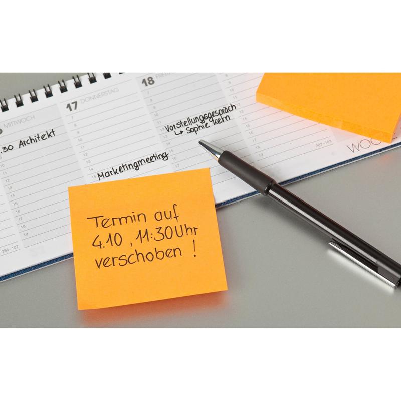 Ένα στυλό βρίσκεται σε έναν ανοιχτό σχεδιαστή δίπλα σε δύο πορτοκαλί Post-it® φύλλα (76 mm x 76 mm, 100 φύλλα/μπλοκ, 100% PEFC) της 3M Deutschland GmbH. Ένα φύλλο μεταθέτει ένα ραντεβού στις 4 Οκτωβρίου στις 11:30 π.μ. στη γερμανική γλώσσα. Χειρόγραφες εγγραφές εμφανίζονται στον σχεδιαστή.