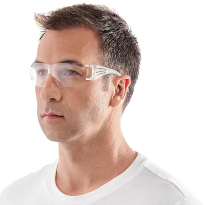 Ένας άντρας που φοράει τα γυαλιά ασφαλείας 3M™ SecureFit™ 200 από την 3M Deutschland GmbH και ένα απλό λευκό T-shirt, κοιτάζει ελαφρώς δεξιά σε ένα λευκό φόντο.