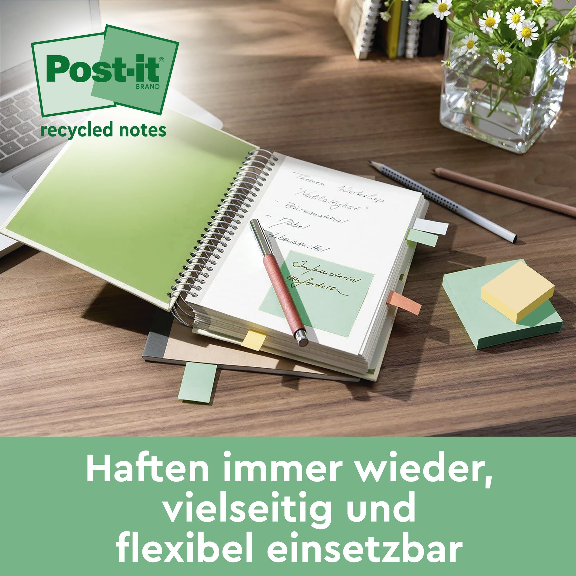 Ein Schreibtisch mit einem aufgeschlagenen Notizbuch mit Post-it® Super Sticky 100% Recycling Notes (47,6 mm x 47,6 mm, 70 Blatt/Block, 100% PEFC) der 3M Deutschland GmbH, einem Kugelschreiber und Bleistift, Büroklammern und einer Glasvase mit grünen Blättern. Der Text in deutscher Sprache erscheint unten.