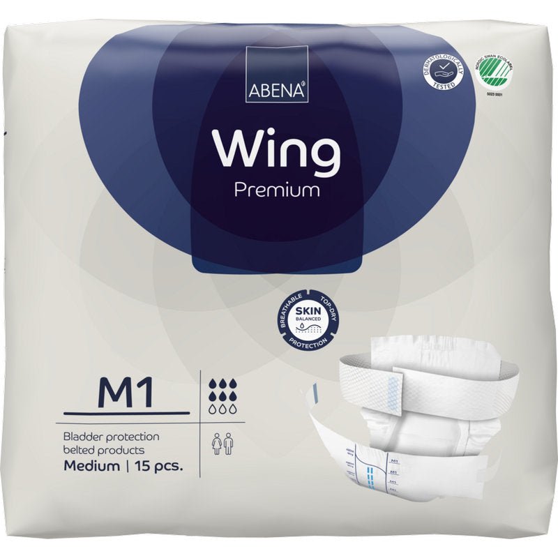 Μια συσκευασία 15 τεμαχίων ABENA Wing Premium ακράτειας με ζώνη, μέγεθος medium, από την Abena Re-Seller GmbH. Η λευκή συσκευασία με σκούρες μπλε πινελιές δείχνει σύμβολα προϊόντος και μια εικόνα της ζώνης για άριστη προστασία και άνεση.