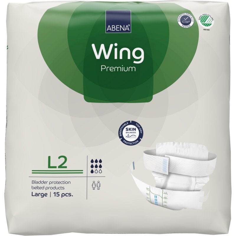 Συσκευασία του ABENA Wing Premium από την Abena Re-Seller GmbH, μέγεθος Large, 15 τεμάχια. Η λευκή-πράσινη συσκευασία δείχνει λεπτομέρειες προϊόντος, μια εικόνα πάνας και τονίζει «προστασία και άνεση» για αξιόπιστη προστασία κύστης.