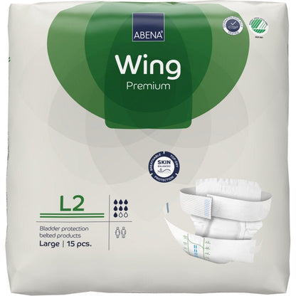 Συσκευασία του ABENA Wing Premium από την Abena Re-Seller GmbH, μέγεθος Large, 15 τεμάχια. Η λευκή-πράσινη συσκευασία δείχνει λεπτομέρειες προϊόντος, μια εικόνα πάνας και τονίζει «προστασία και άνεση» για αξιόπιστη προστασία κύστης.