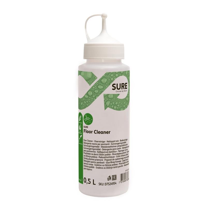 Ένα μπουκάλι δοσομέτρησης 0,5L SURE Floor Cleaner από την Diversey Deutschland GmbH & Co. OHG με λευκό καπάκι/στόμιο και πράσινη ετικέτα με οδηγίες δοσομέτρησης και μοτίβο φύλλου. Αυτό το φιλικό προς το περιβάλλον καθαριστικό χρησιμοποιεί μια φυτική φόρμουλα για αποτελεσματικό καθαρισμό.
