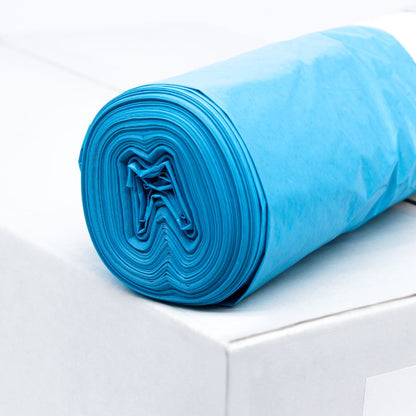 Ένας ρολός μπλε σακούλας απορριμμάτων DEISS LDPE τύπου 60, 20772, 70 λίτρων από την EMIL DEISS KG (GmbH + Co.) βρίσκεται πάνω σε ένα λευκό κουτί. Αυτές οι ανθεκτικές σακούλες, γνωστές για την αντοχή τους στο σκίσιμο, είναι τακτικά τυλιγμένες, ώστε να φαίνεται η στρωματική δομή του ανακυκλώσιμου υλικού. Το φόντο παραμένει απλό και μινιμαλιστικό.