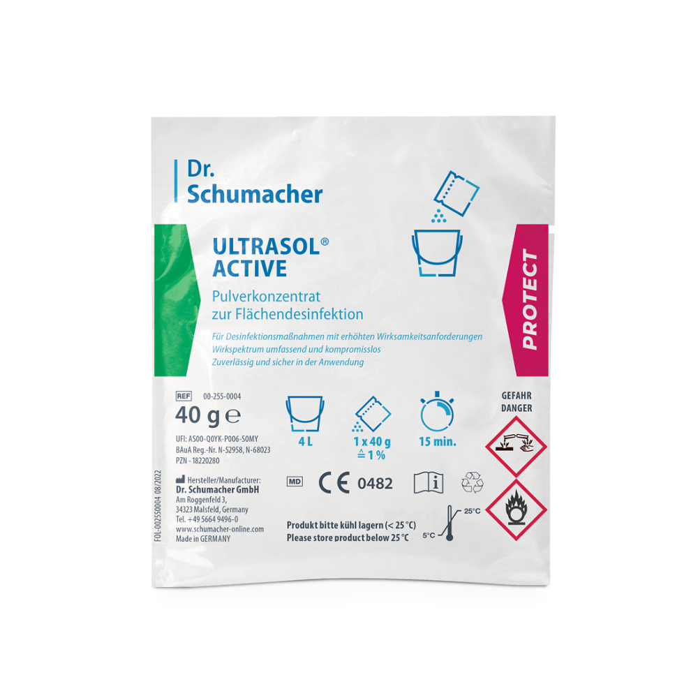 Μια συσκευασία Dr. Schumacher Ultrasol® Active Απολύμανση Επιφανειών της Dr. Schumacher GmbH περιέχει συμπυκνωμένη σκόνη για απολύμανση επιφανειών. Η λευκή συσκευασία με πράσινες και ροζ πινελιές περιέχει κείμενο και σύμβολα που υποδεικνύουν ότι περιέχει 40 γραμμάρια συμπυκνωμένης σκόνης για απολύμανση επιφανειών και πρέπει να φυλάσσεται κάτω από 25 °C. Στη συσκευασία υπάρχουν επίσης σύμβολα κινδύνου.
