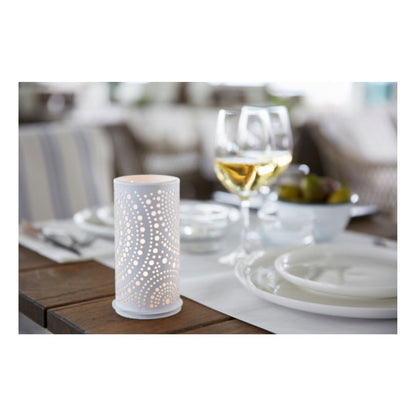 Σε ένα τραπέζι δείπνου υπάρχουν λευκά πιάτα, μαχαιροπίρουνα και ποτήρια κρασιού με λευκό κρασί. Στο προσκήνιο βρίσκεται εμφανώς η μεταλλική βάση κεριών Billy 140 x 75 mm με μοτίβο κουκκίδων της Duni GmbH, ενώ στο παρασκήνιο υπάρχει ένα μπολ με σταφύλια.