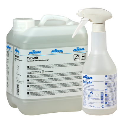 Ένας δοχείο 5 λίτρων και ένα μπουκάλι ψεκασμού 750 ml, και τα δύο με την επιγραφή "Kiehl Tablefit Kunststoff- und Schreibtischreiniger" της Johannes Kiehl KG, είναι εξοπλισμένα με λευκές και μπλε ετικέτες με πληροφορίες προϊόντος και λογότυπα και περιέχουν ένα υγρό καθαριστικό διάλυμα.