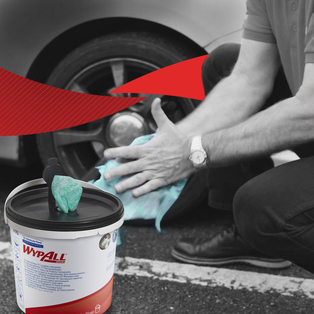 Eine Person kniet, um Autoräder mit grünen WypAll® Wischtüchern der Kimberly-Clark GmbH zu reinigen. Im Vordergrund steht ein sichtbarer Behälter mit 6 Eimern x 90 Blatt. Der schwarz-weiße Hintergrund weist einen kräftigen roten grafischen Akzent auf.