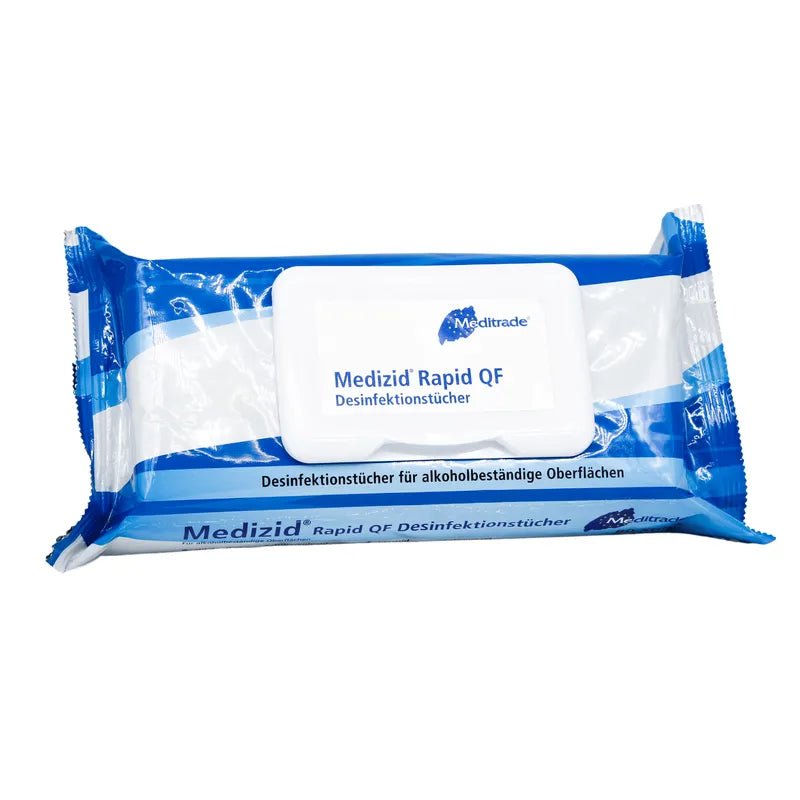 Ένα συσκευασμένο πανί απολύμανσης Meditrade Medizid® Rapid QF Flowpack για επιφάνειες ανθεκτικές στο αλκοόλ, απεικονισμένο μπροστά από ένα λευκό φόντο. Η συσκευασία είναι μπλε και λευκή με γερμανικό κείμενο.