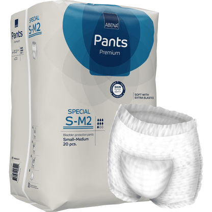 Μια συσκευασία ABENA Pants Special Premium από την Abena Re-Seller GmbH, μέγεθος S-M2 (20 κομμάτια), απεικονίζεται δίπλα σε ένα ανοιχτό λευκό παντελόνι ενηλίκων. Η συσκευασία τονίζει την προστασία του δέρματος και τις επιπλέον ελαστικές ζώνες.