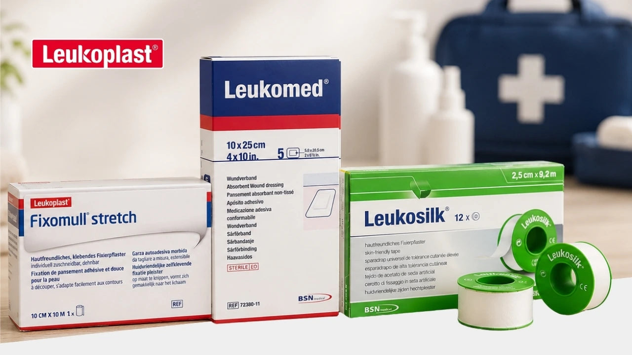 Werbebanner von Leukoplast mit den Produkten Fixomull Stretch, Leukomed und Leukosilk sowie mehreren Pflasterrollen. Im unscharfen Hintergrund steht eine dunkelblaue Erste-Hilfe-Tasche mit weißem Kreuz.