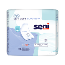 Μια συσκευασία Seni Soft Super Dry προστατευτικών επιστρωμάτων κρεβατιού της TZMO Deutschland GmbH σε μπλε-λευκό σχέδιο περιέχει 15 υποστρώματα μίας χρήσης (90 x 60 cm) με το λογότυπο του προϊόντος και σημαντικές λειτουργίες στην μπροστινή πλευρά.
