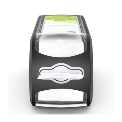 Απεικονίζεται η θήκη για χαρτοπετσέτες Tork Xpressnap Fit® 272901 από την Essity Professional Hygiene Germany GmbH. Αυτή η μαύρη-γκρίζα θήκη διαθέτει μια διαφανή μπροστινή πλευρά που περιέχει λευκές χαρτοπετσέτες και μια πράσινη διαφημιστική επιφάνεια στην κορυφή. Το λογότυπο "Tork" είναι ορατό και υπογραμμίζει το αποδοτικό σύστημα διανομής μονών χαρτοπετσετών του Tork Xpressnap Fit.