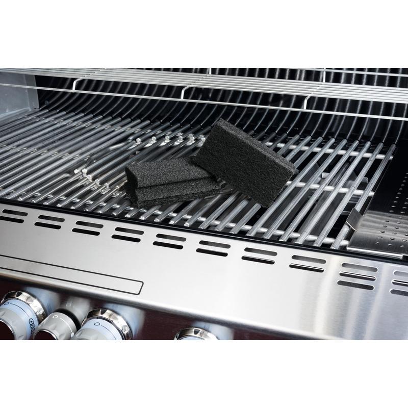 Ένα Scotch-Brite® Grill Griffschwamm από την 3M Deutschland GmbH βρίσκεται σε μια ανοξείδωτη ψησταριά και τονίζει τον εύκολο καθαρισμό ψησταριάς. Στη σχάρα είναι ορατά τα μαύρα σφουγγάρια, τα κουμπιά της ψησταριάς και το ανοιχτό καπάκι.