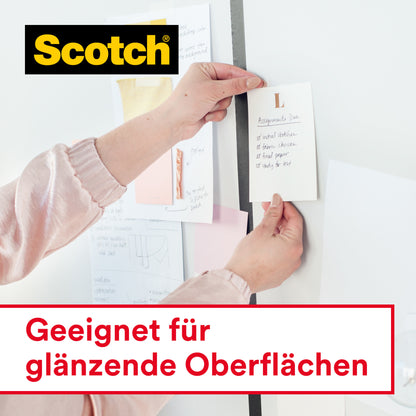 Eine Person befestigt einen Zettel an einer Wand mit Scotch® Crystal Klebeband 6-1925D von 3M Deutschland GmbH (19 mm x 25 m, auf Handabroller). Verschiedene Zettel hängen an der Wand. Text: "Geeignet für glänzende Oberflächen".