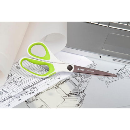 Ένα ζευγάρι ψαλίδια Scotch™ Titan, 20 cm από την 3M Deutschland GmbH, με λευκές και πράσινες λαβές, αναπαύεται σε αρχιτεκτονικά σχέδια δίπλα σε ένα ασημένιο φορητό υπολογιστή και ένα ρολό διάφανου χαρτιού.