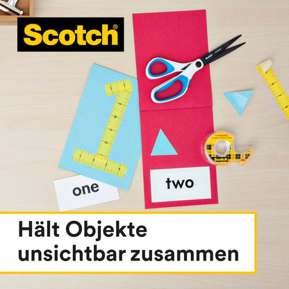 Σε ένα τραπέζι βρίσκονται ένα ρολό Scotch® διπλής όψης ταινία της 3M Deutschland GmbH (12 mm x 33 m), ένα ψαλίδι, μια κίτρινη μετροταινία και χαρτί με αριθμούς και σχήματα. Το γερμανικό κείμενο λέει: "Κρατά αντικείμενα αόρατα μαζί."