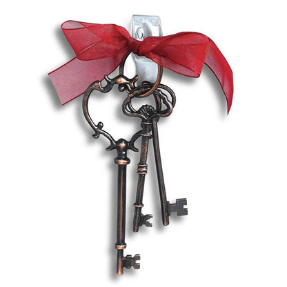 Τρία διακοσμητικά, αντίκα κλειδιά σε μπρελόκ με κόκκινη κορδέλα κρέμονται σε λευκό τοίχο με 3M Deutschland GmbH Command™ Mini-Haken, transparent, mit transparenten Strips, 17006CLRFGN-τέλεια για αποθήκευση χωρίς τρύπημα.