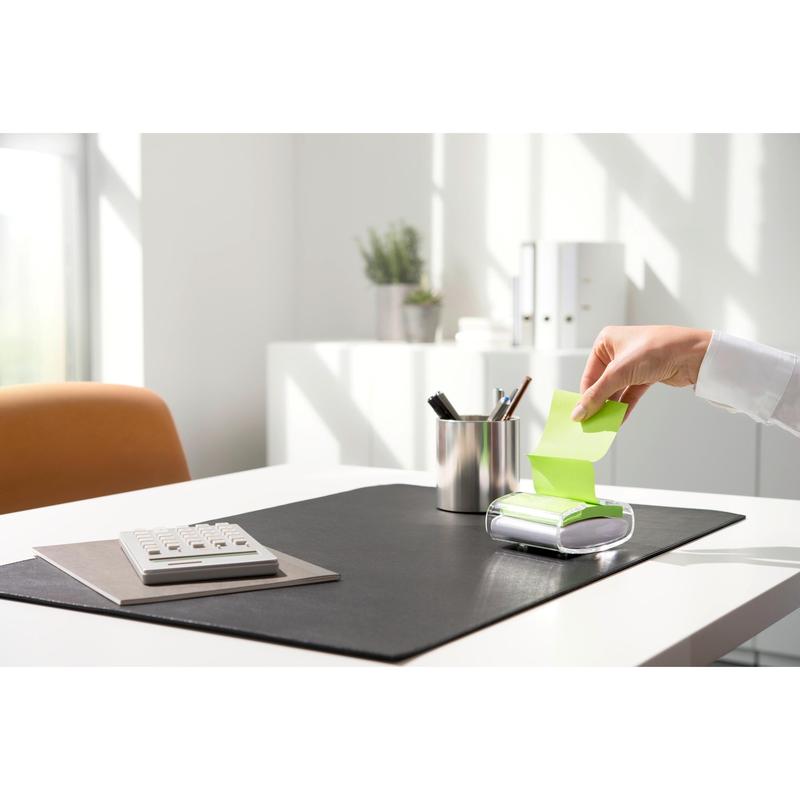 Ένα άτομο τραβάει μια κίτρινη Post-it® Super Sticky Z-Note (76 x 76 mm) από τον μαύρο PRO Post-it® Z-Notes Dispenser της 3M Deutschland GmbH, σε ένα τακτοποιημένο γραφείο με αριθμομηχανή, θήκη στυλό και μαύρη βάση σε έντονο φως της ημέρας.