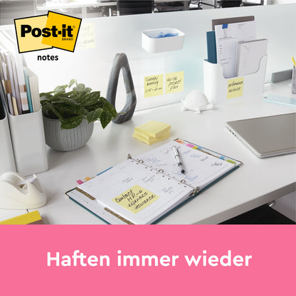 Ein aufgeräumter Büroschreibtisch mit 3M Deutschland GmbH Post-it® Notes in Gelb (76x102mm, 100 Blatt/Block, 12 Blöcke), sichtbar auf Papieren und Trennwänden. Der Text lautet "Haften immer wieder" mit dem Post-it Markenlogo in der Ecke.